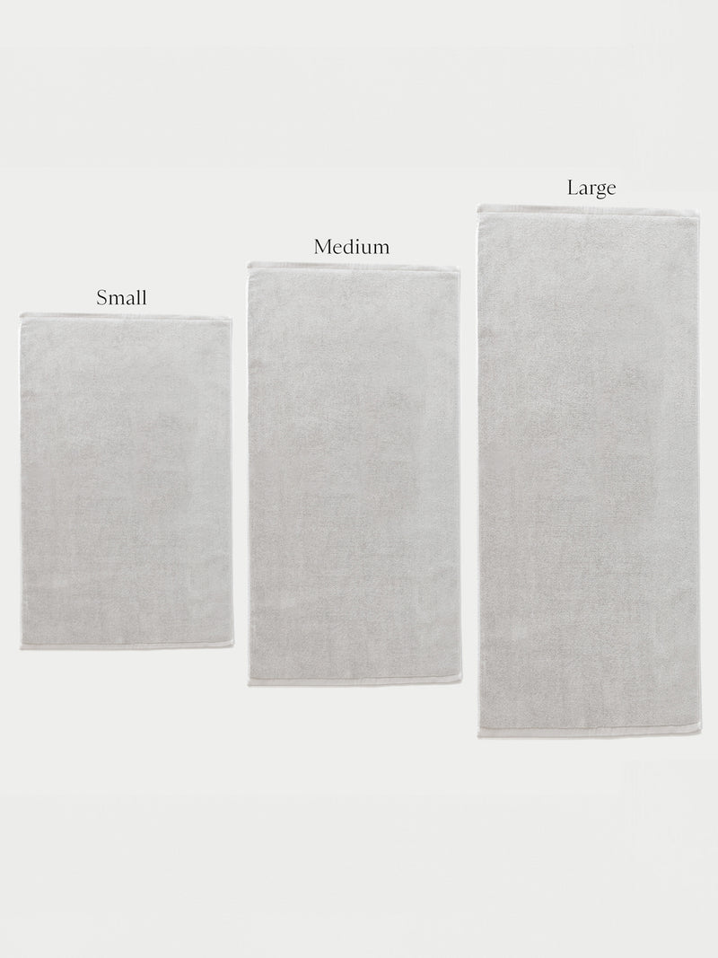 Three Cozy Earth Loop Terry Bath Mats in small, medium, and large are displayed side by side against a white background, each labeled above with its size.