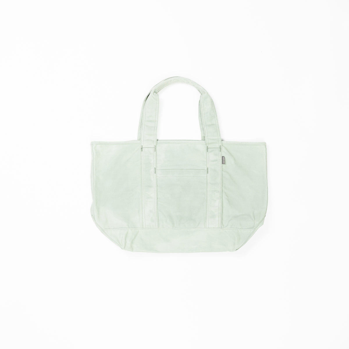 A light green Waxed Canvas Tote from Cozy Earth with two handles is centered on a white background. The tote bag features a front pocket with a zipper, visible seams, and a rectangular shape, providing ample storage space. 