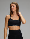 A person wearing a black, scoop-neck Women’s Balance Bra by Cozy Earth with a branded elastic band.|Color:Jet Black