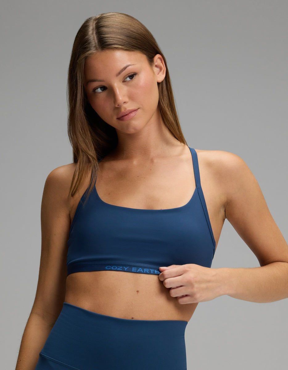 A woman wearing a dark blue Cozy Earth Women’s Balance Bra with thin straps and a branded elastic band.|Color:Obsidian