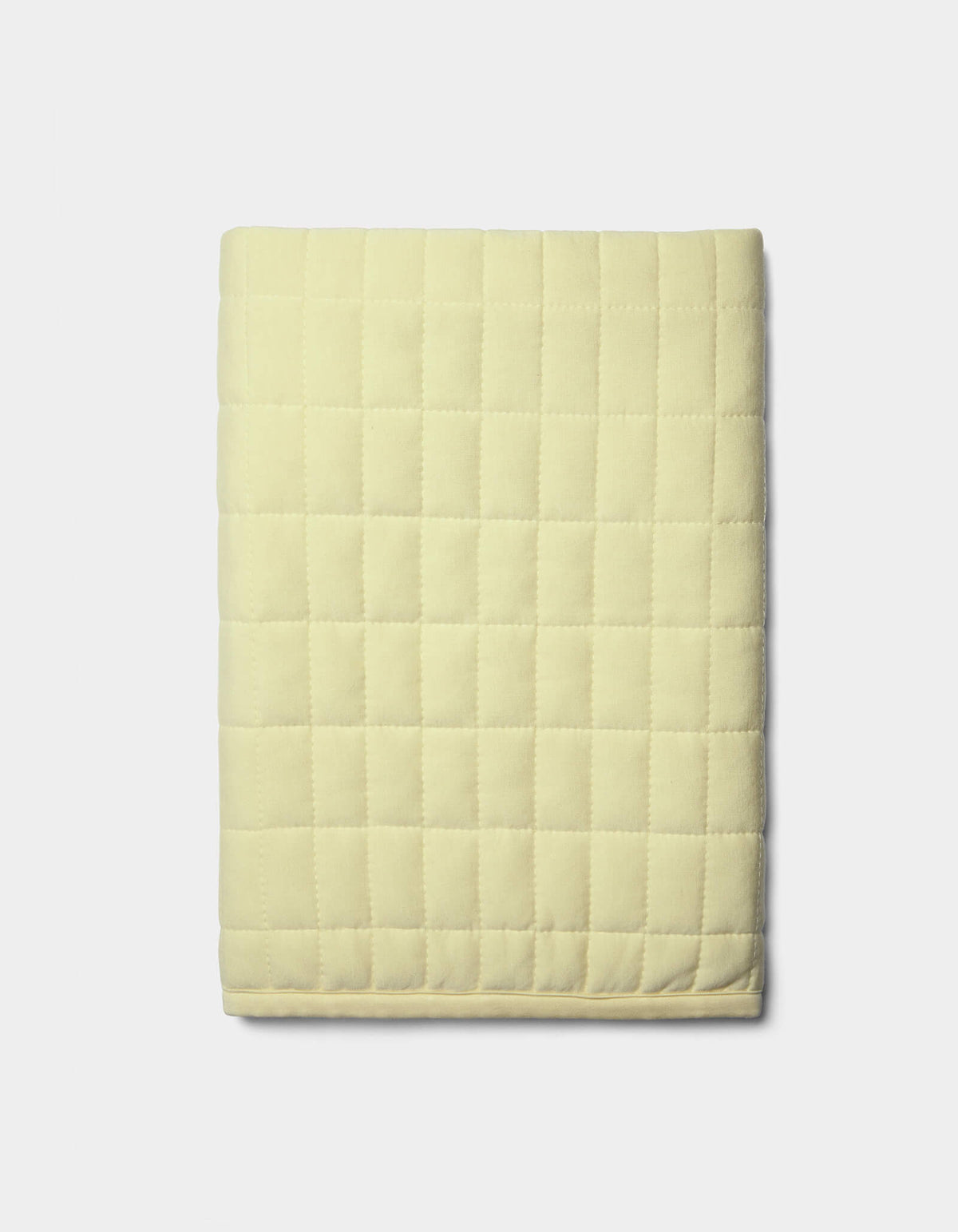The Cozy Earth Bamboo Jersey Quilted Shams in light yellow, featuring a square grid pattern, are neatly displayed against a plain white background.