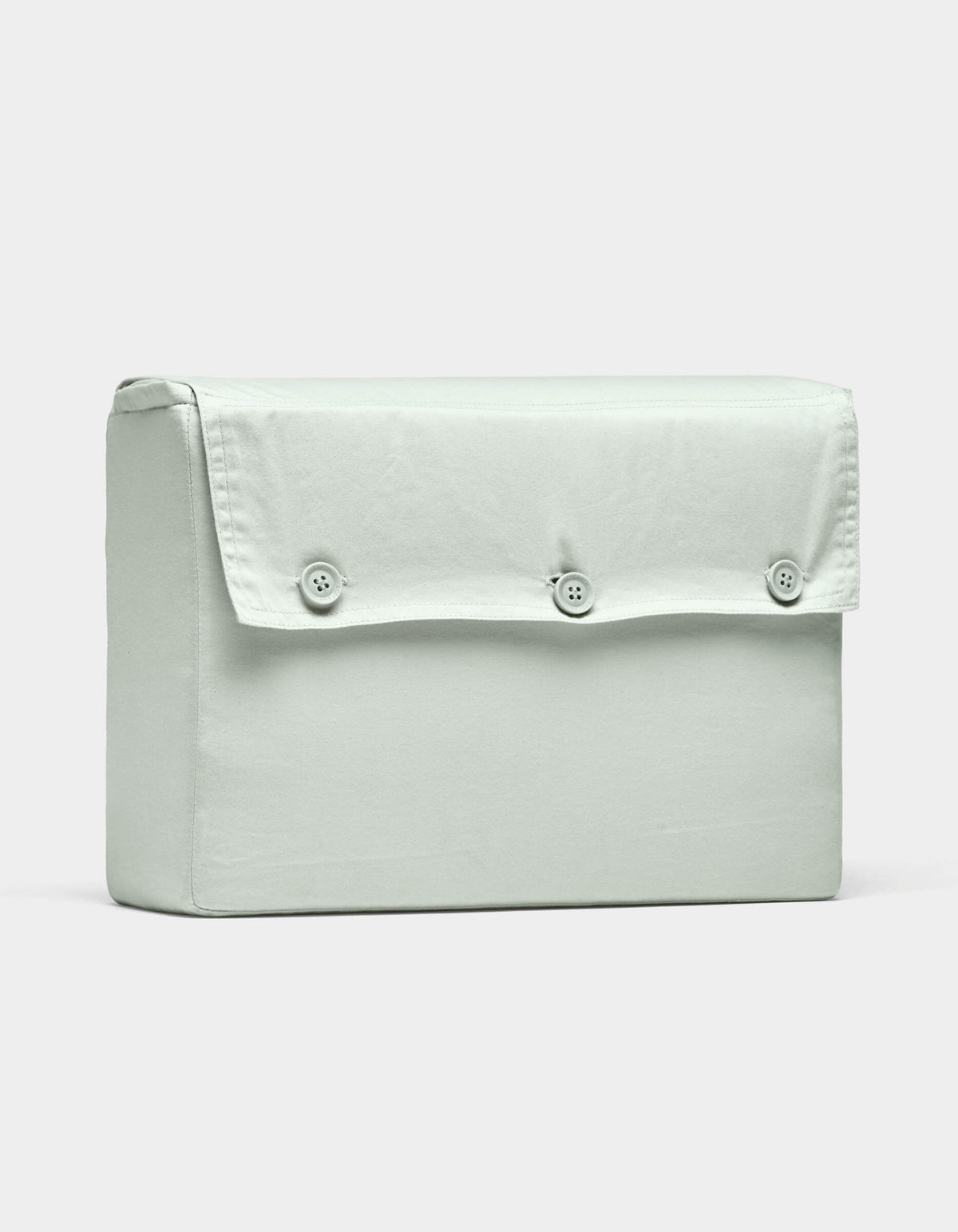 The Soft-Wash Cotton Sheet Set by Cozy Earth is displayed on a plain white background, featuring light grey fabric and a rectangular shape with a flap secured by three buttons.