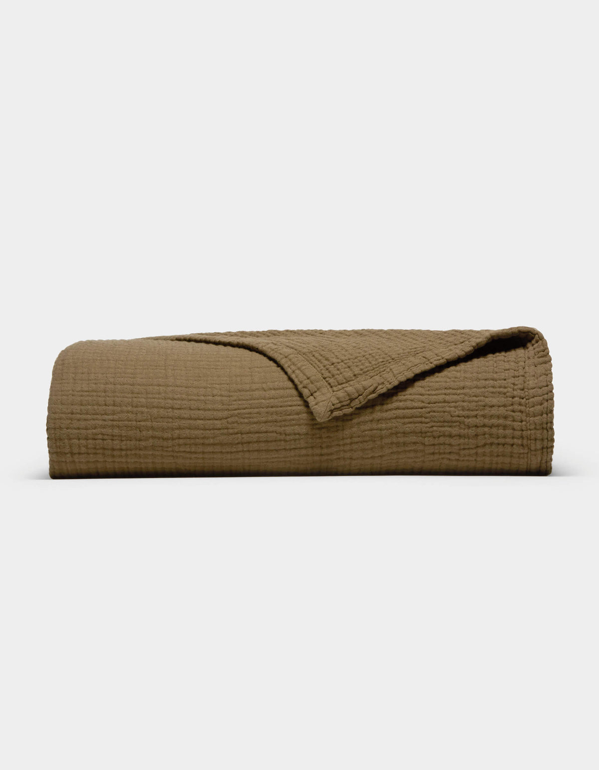 The Cozy Earth Cotton Gauze Blanket, featuring a folded, textured brown design with a corner turned back to reveal its soft inner side, is displayed against a plain white background.|Color:Sable