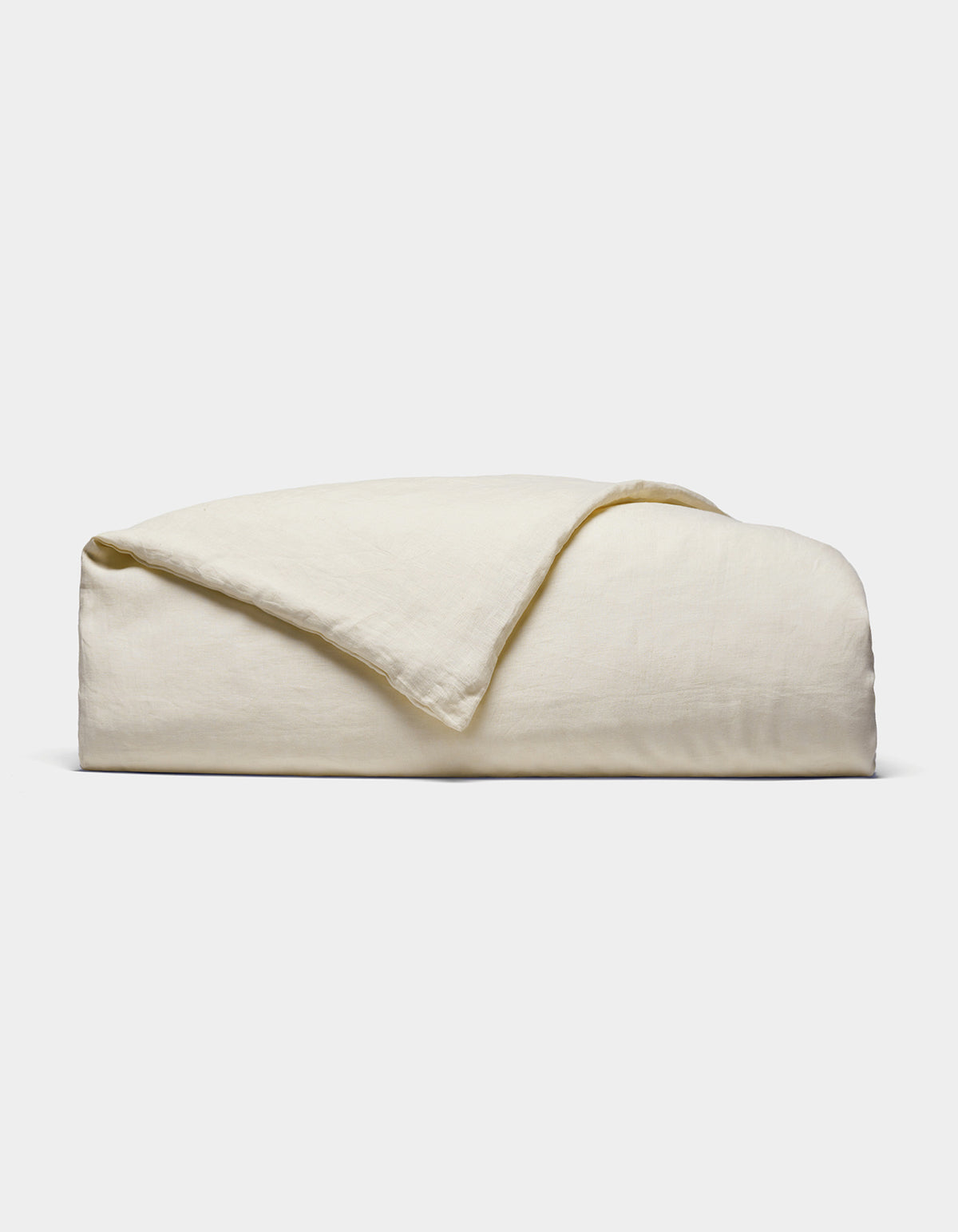 The Cozy Earth Linen Duvet Cover, in an off-white shade, is neatly folded against a white background. Its soft, slightly textured fabric is visible with one corner casually turned over.