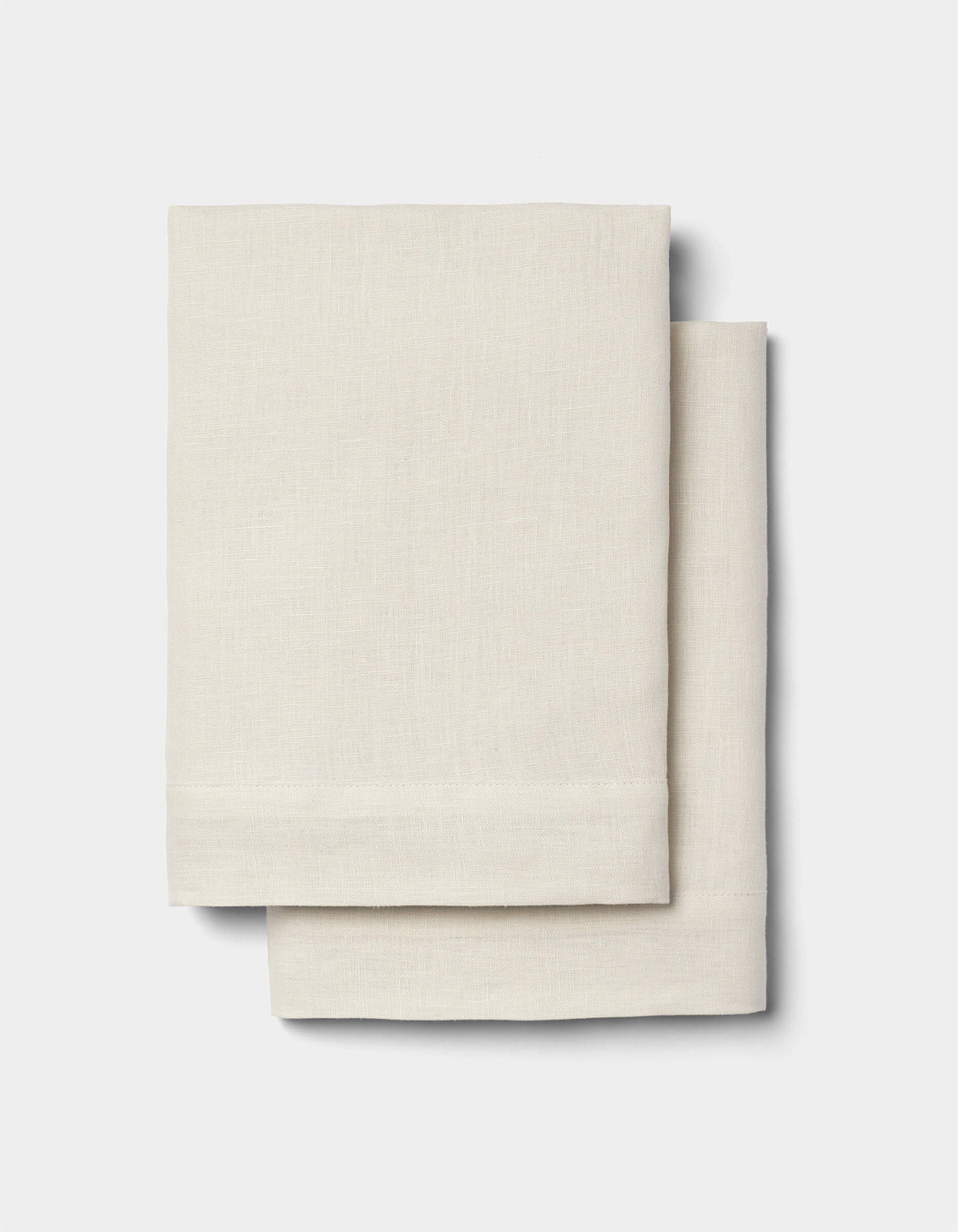 Two neatly folded Cozy Earth Linen Shams in light beige are stacked together against a plain white background.