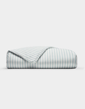 The Cozy Earth Soft-Wash Cotton Duvet Cover features neat light blue and white vertical stripes, displayed folded on a plain white background with one corner turned to show the underside pattern.|Color:River and Sea Salt Stripe