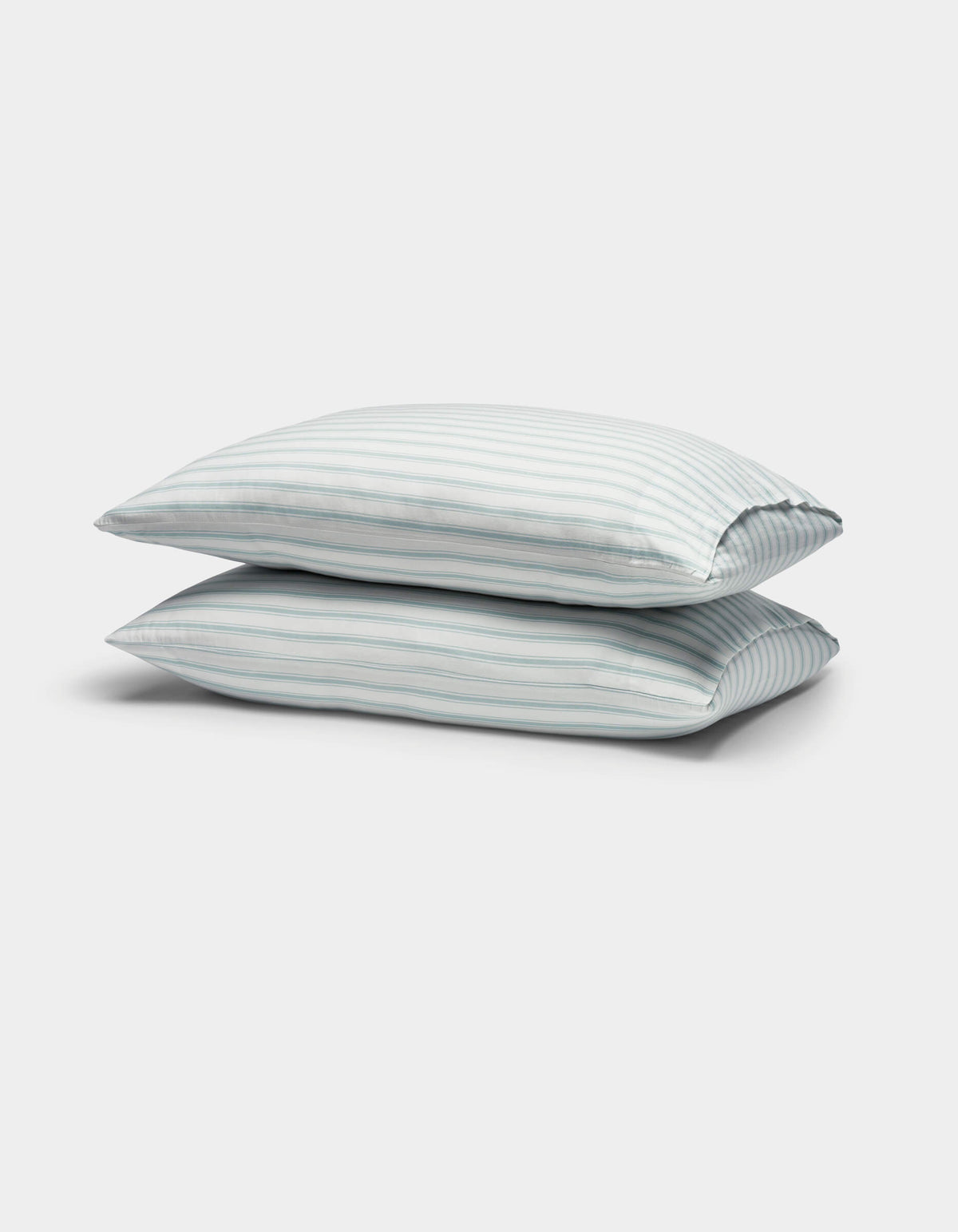 Two Soft-Wash Cotton Pillowcases by Cozy Earth, featuring light blue and white vertical stripes, are stacked against a plain white background.