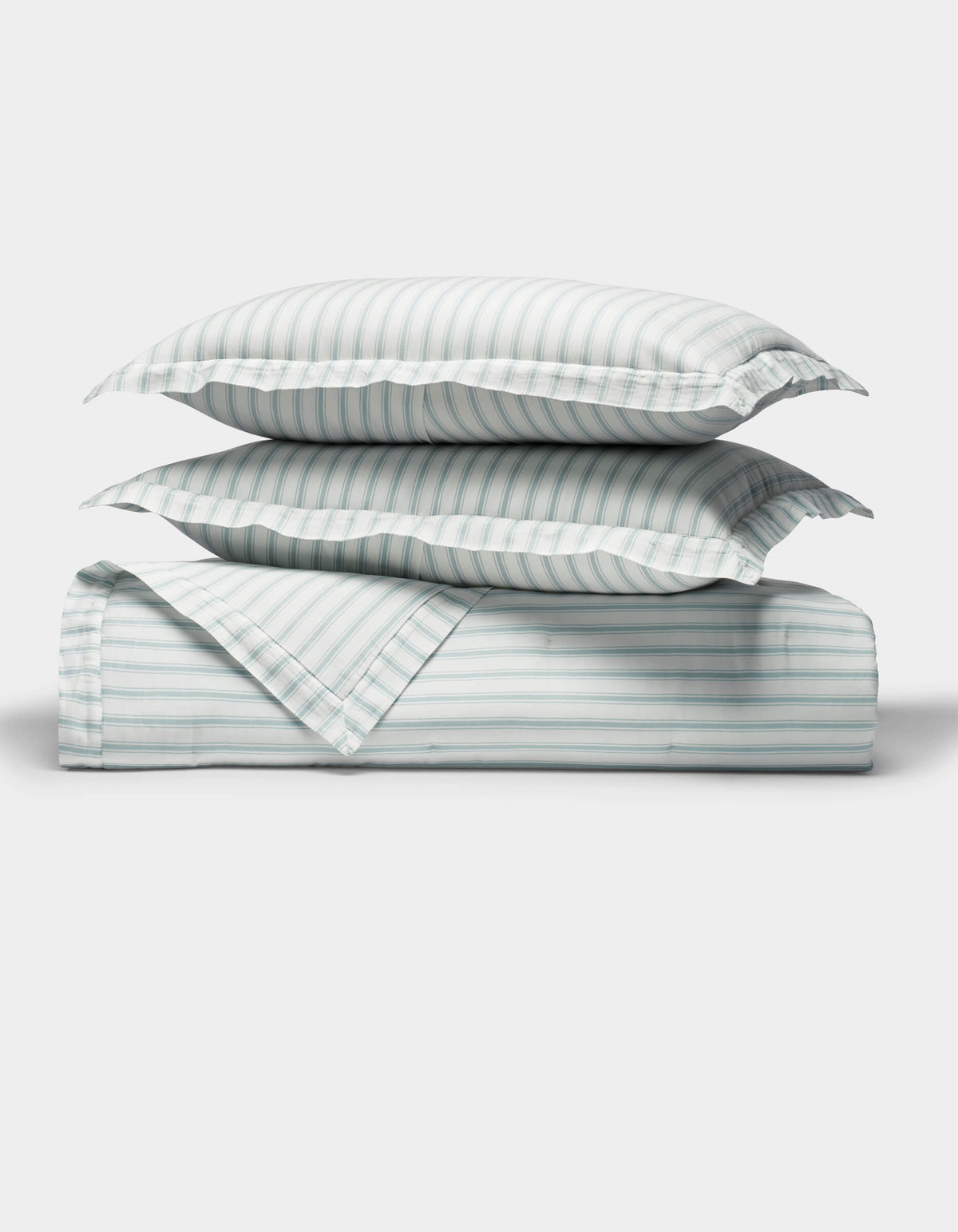 The Cozy Earth Soft-Wash Cotton Quilt Set, featuring two pillows and a folded quilt with light blue and white vertical stripes, is neatly arranged on a white background, highlighting its soft texture.