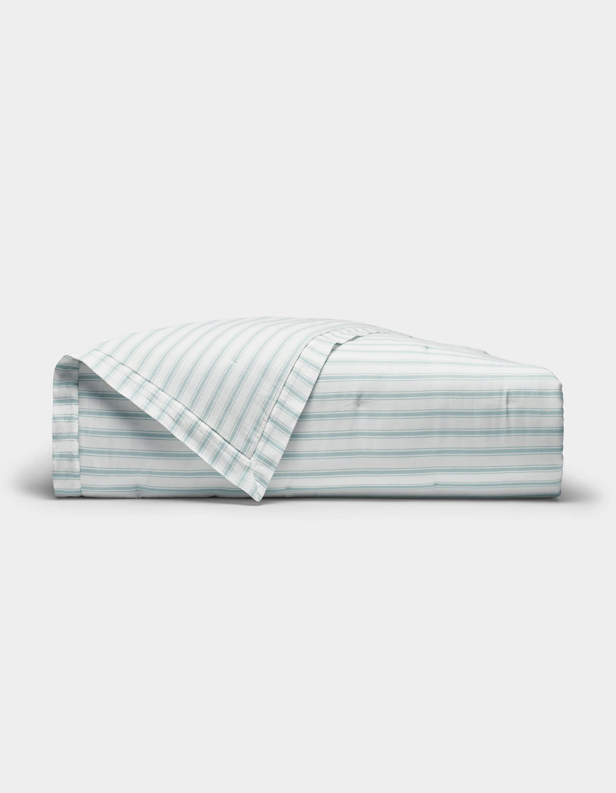 The Cozy Earth Soft-Wash Cotton Quilt is shown neatly folded with one corner turned back, revealing its light color and thin horizontal blue and gray stripes against a plain white background.|Color:River and Sea Salt Stripe