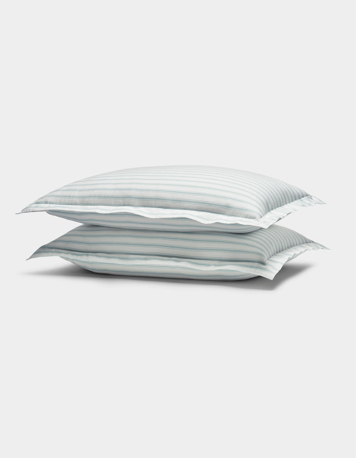The image shows two Soft-Wash Cotton Shams by Cozy Earth, featuring light blue and white horizontal stripes, stacked against a plain white background.|Color:River and Sea Salt Stripe