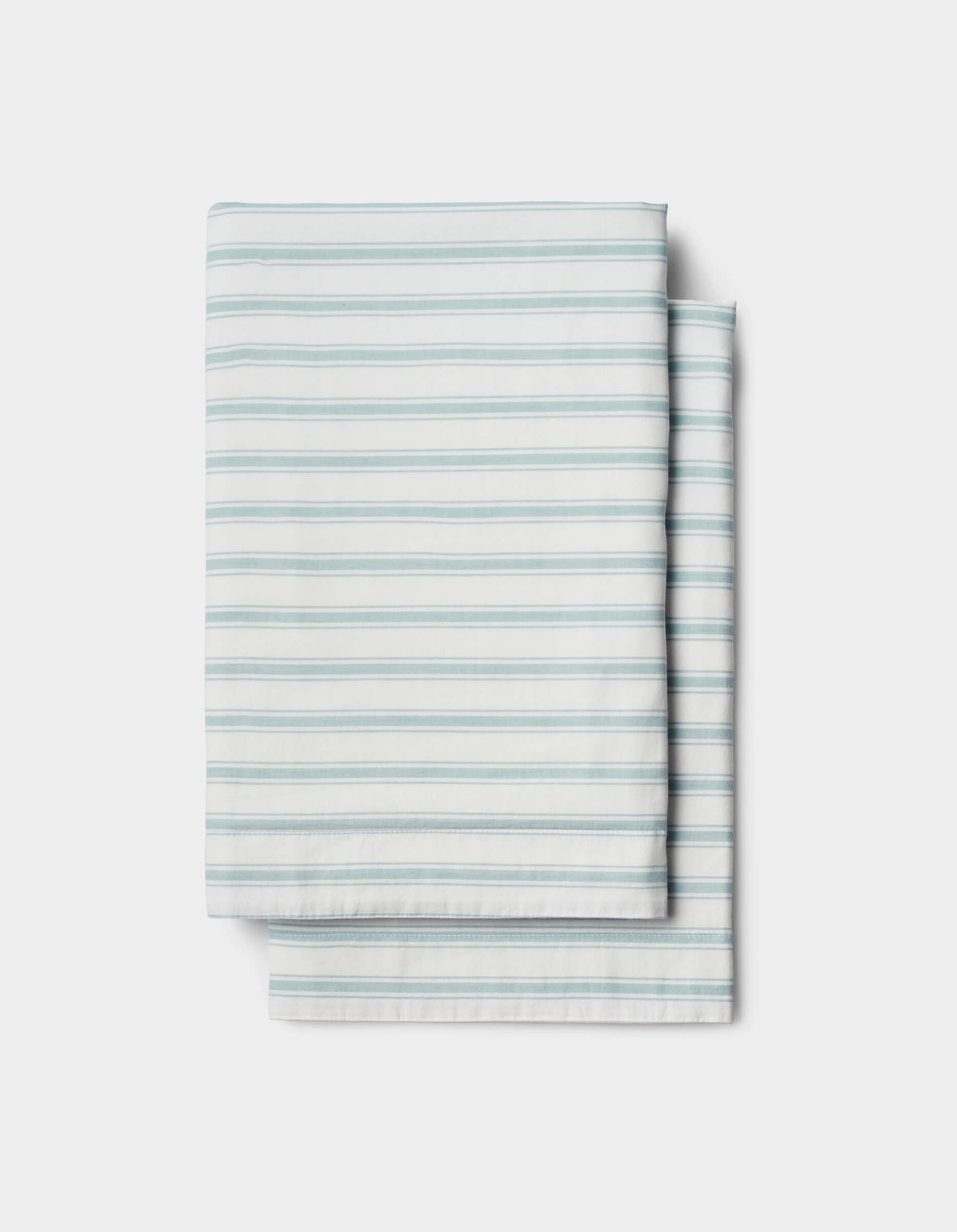A Soft-Wash Cotton Sham by Cozy Earth, featuring light blue horizontal stripes on white, is neatly folded and set against a plain white background.