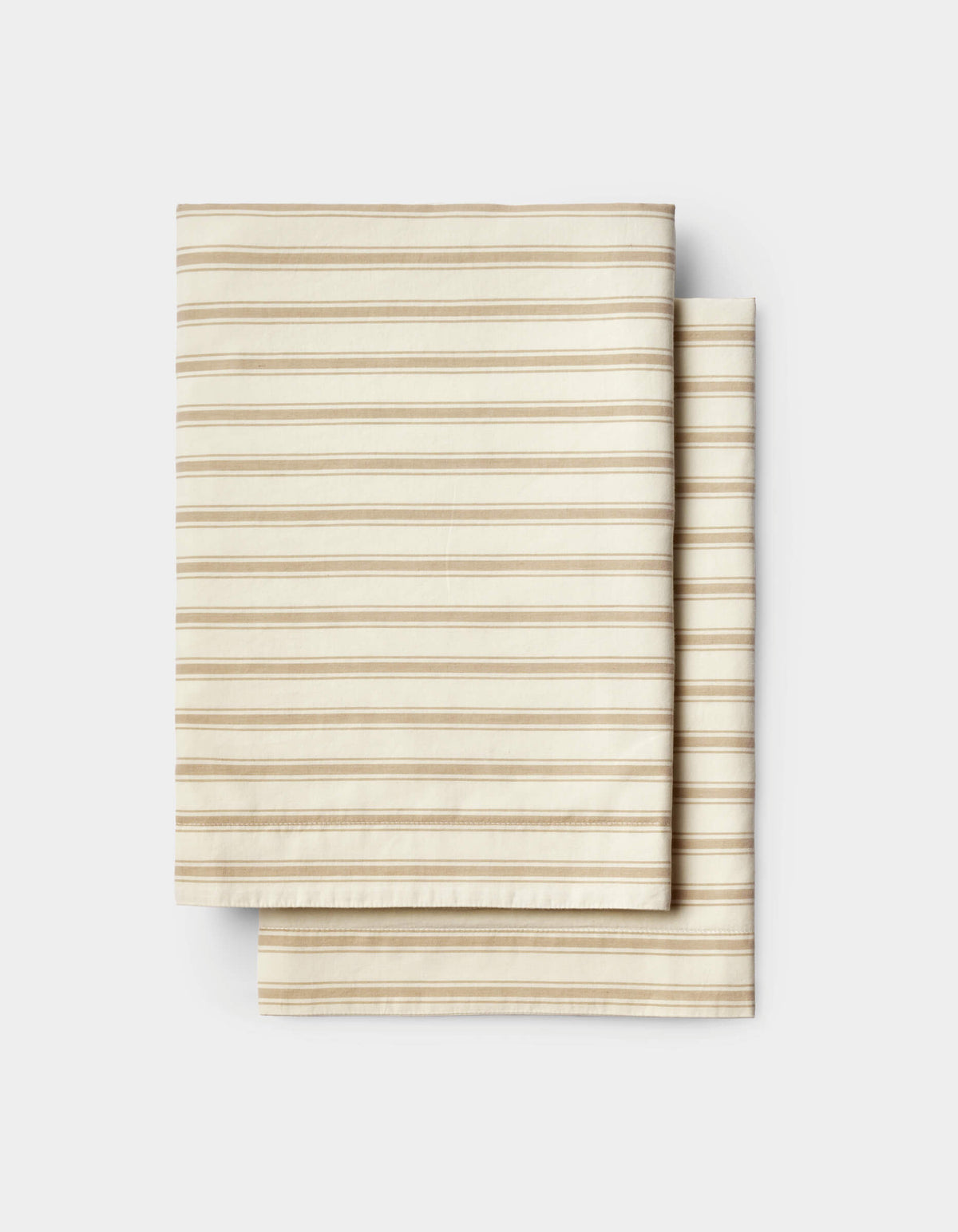 Neatly stacked on a white background, the Cozy Earth Soft-Wash Cotton Sheet Set features folded beige fabric with thin, evenly spaced horizontal brown stripes.