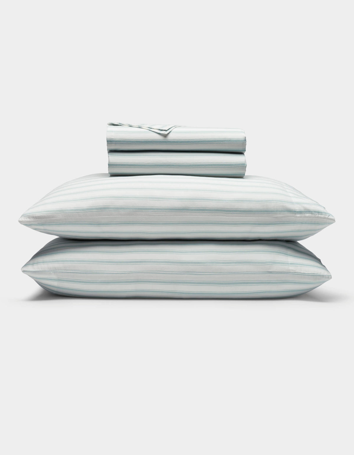 A neatly folded Soft-Wash Cotton Sheet Set by Cozy Earth in light blue and white stripes, featuring two stacked pillows and a folded fitted sheet, displayed on a plain white background.|Color:River and Sea Salt Stripe