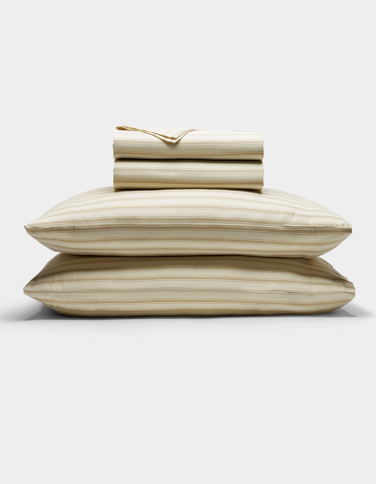 The Cozy Earth Soft-Wash Cotton Sheet Set in beige and light brown stripes is neatly stacked with two pillows at the base, topped with folded sheets and a pillowcase, displayed against a plain white background.