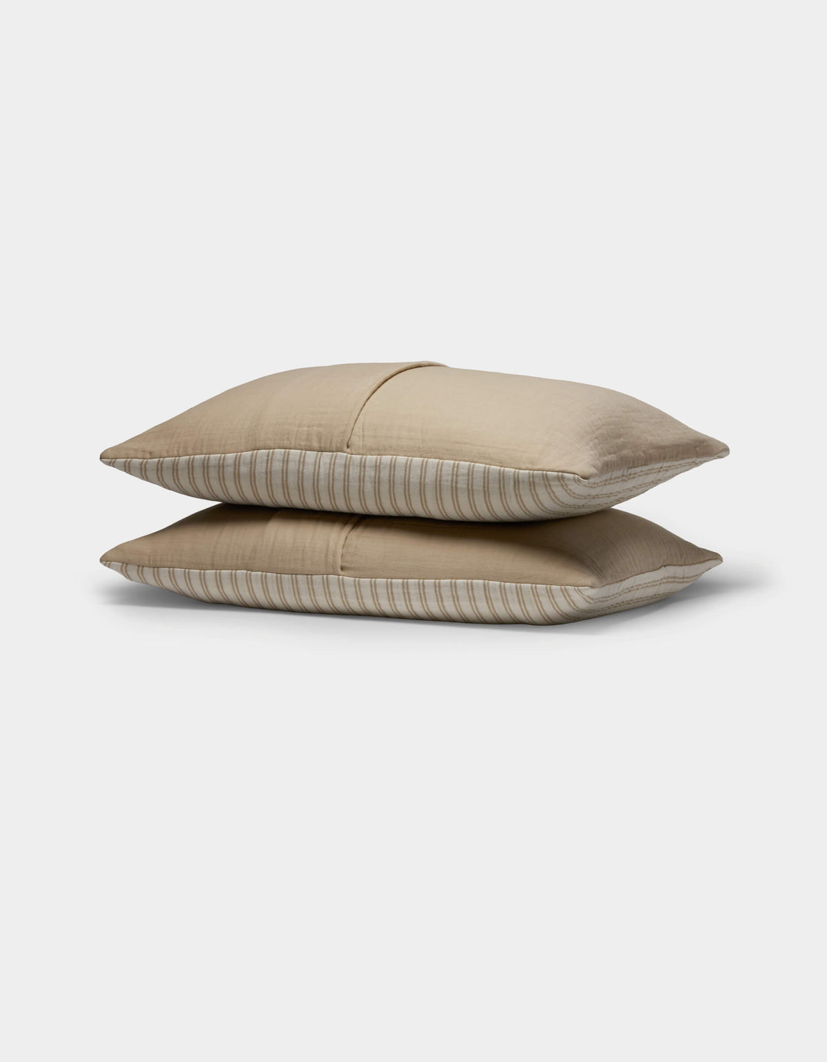 Two Cozy Earth Waterfront Shams in light brown with subtle horizontal stripes are stacked together against a plain white background.