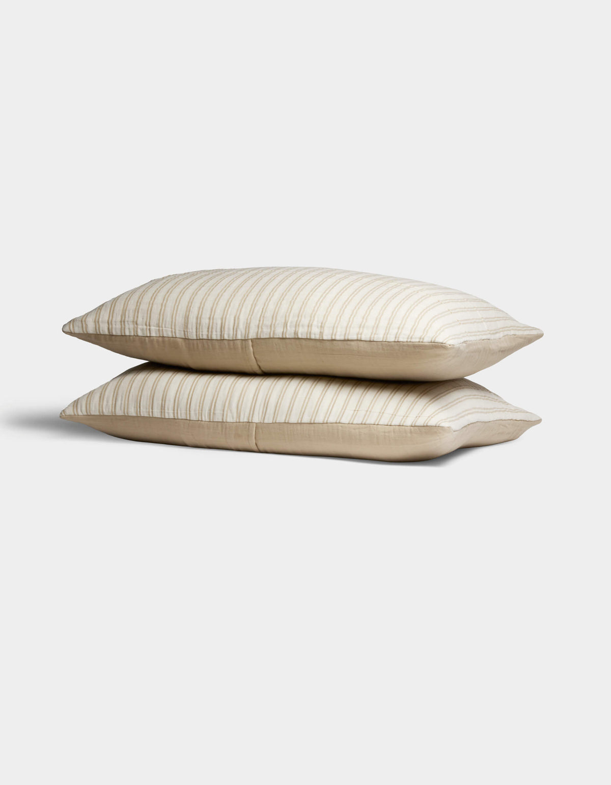 Two Cozy Earth Waterfront Shams in beige, featuring subtle horizontal stripes, are stacked against a plain white background.