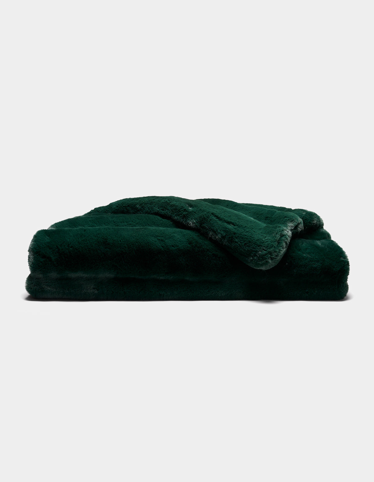A Cozy Earth Channel Cuddle Blanket in dark green, featuring plush fur, is neatly folded and stacked against a plain white background.|Color:Emerald