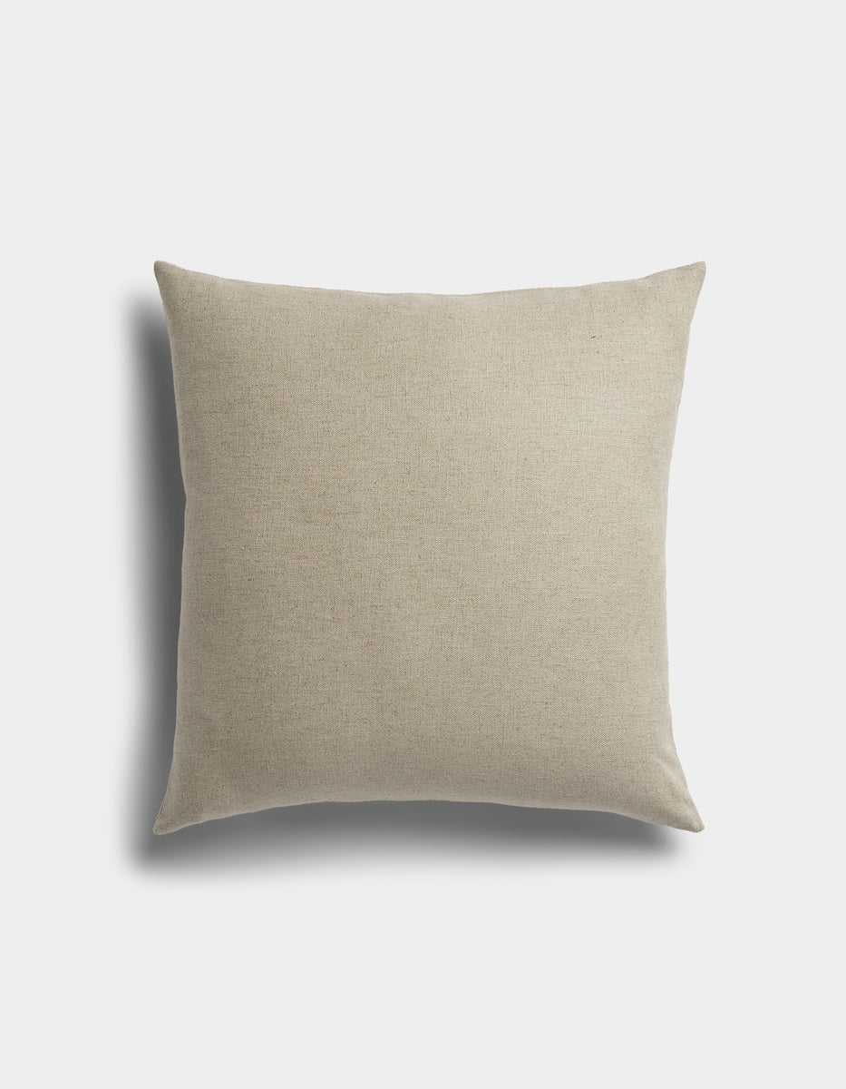 The Sonoma Throw Pillow by Cozy Earth is a square beige cushion with a plain fabric cover, displayed against a white background featuring a faint shadow on the left side.