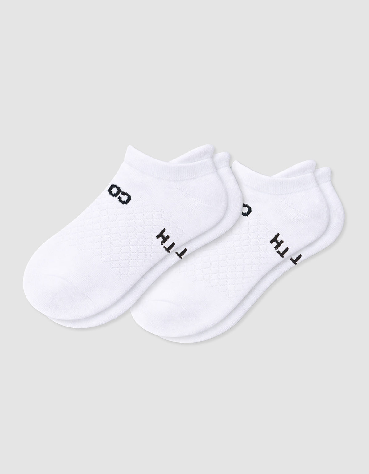 The Women's Essential Ankle Sock by Cozy Earth features a textured white design with subtle black text near the cuff, shown on a light gray background.