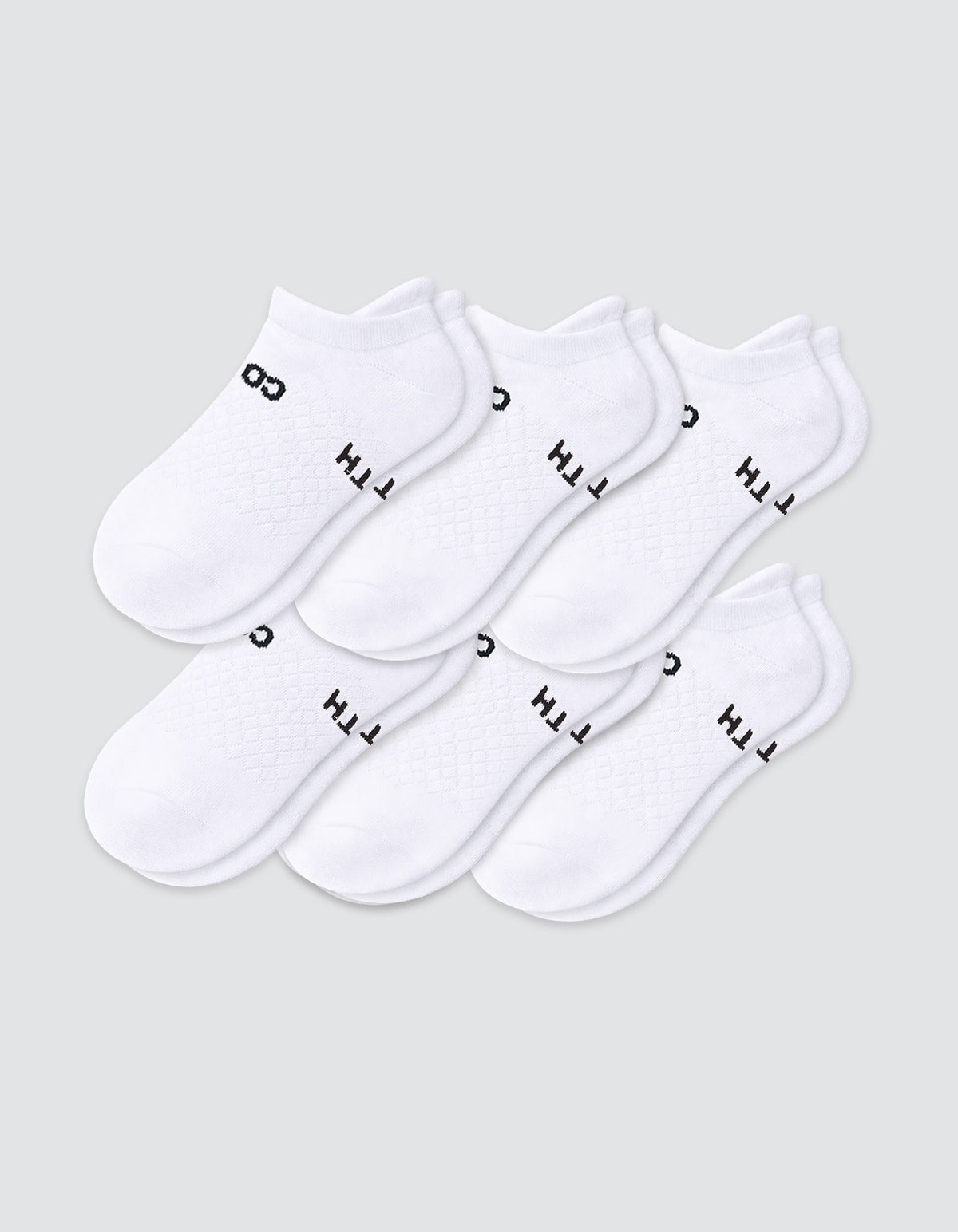 Six pairs of Cozy Earth Women's Essential Ankle Socks in white, featuring black text near the elastic opening, are arranged in two overlapping rows on a light gray background.