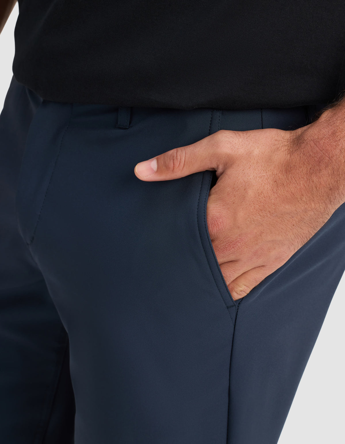 A close-up of a person wearing Cozy Earth Men's Everywhere Short in dark blue and a black shirt, with their right hand placed inside the short’s pocket.