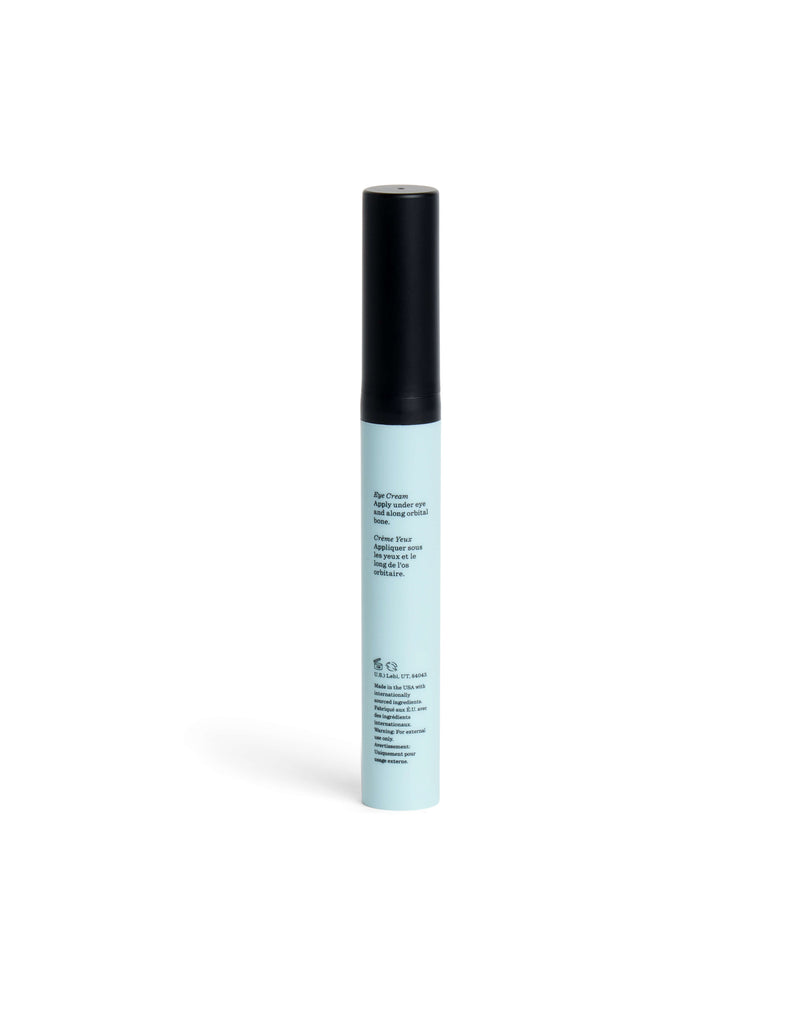 A slim, light blue Eye Cream tube from Cozy Earth with a black cap stands upright on a white background. The front features small, black printed text.