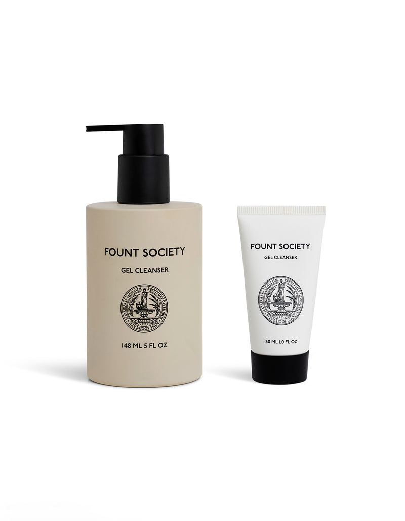Two Cozy Earth skincare products: the Gel Cleanser in a 148 ml beige bottle with black pump and a 30 ml white tube, both featuring black logo and text, are displayed on a white background.