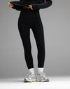 A person wearing black Women’s Liv Leggings with Pockets, white socks, and silver running shoes.|Color:Jet Black