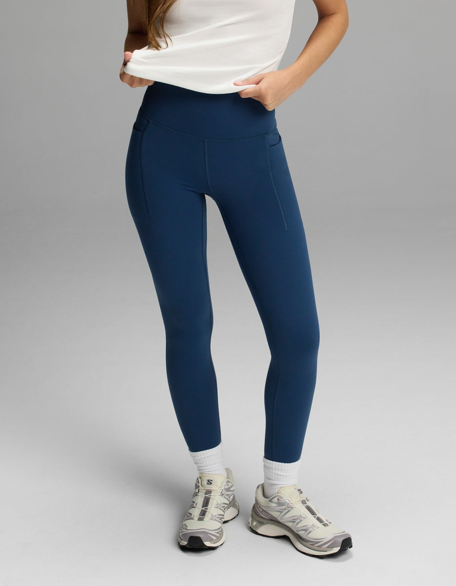 Cozy Earth Women’s Liv Leggings with Pockets in navy blue, styled with white socks and neutral sneakers.