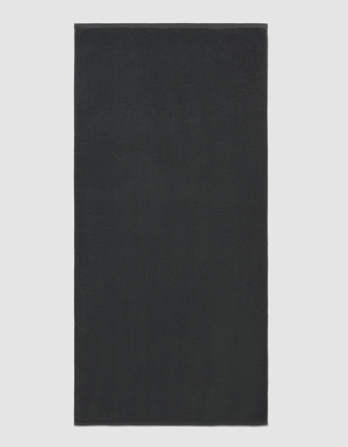 The Cozy Earth Loop Terry Bath Mat is rectangular and solid dark gray with a soft, uniform texture, shown against a plain light background.|Color:Graphite