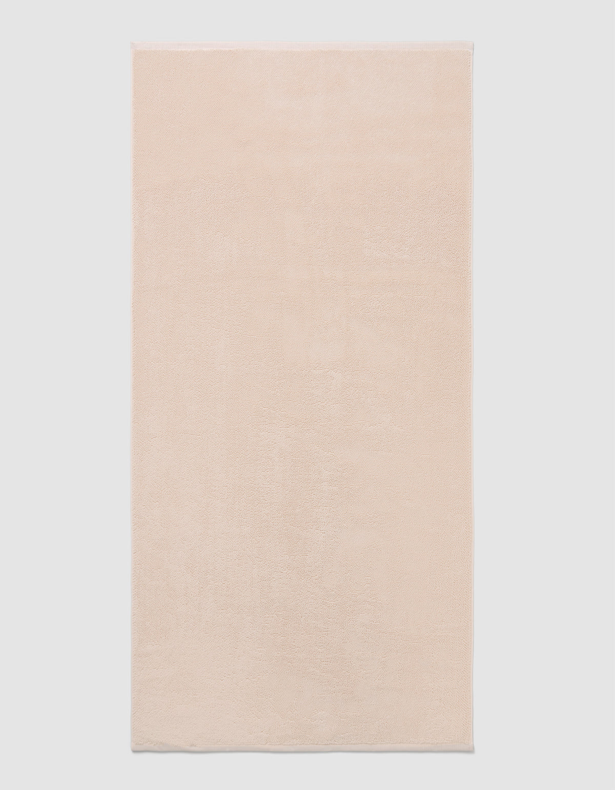 The Cozy Earth Loop Terry Bath Mat, a rectangular bath mat in light beige with a soft, plush texture, is displayed against a plain white background.|Color:Petal
