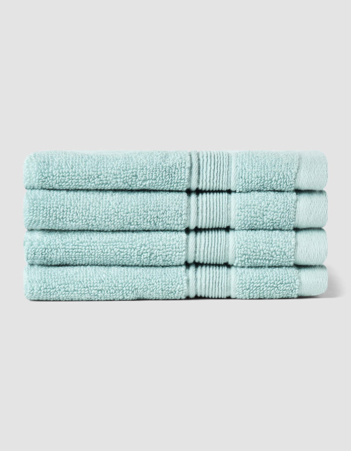 Four neatly folded Luxe Washcloths by Cozy Earth, in light blue, stacked on top of each other against a plain light gray background.