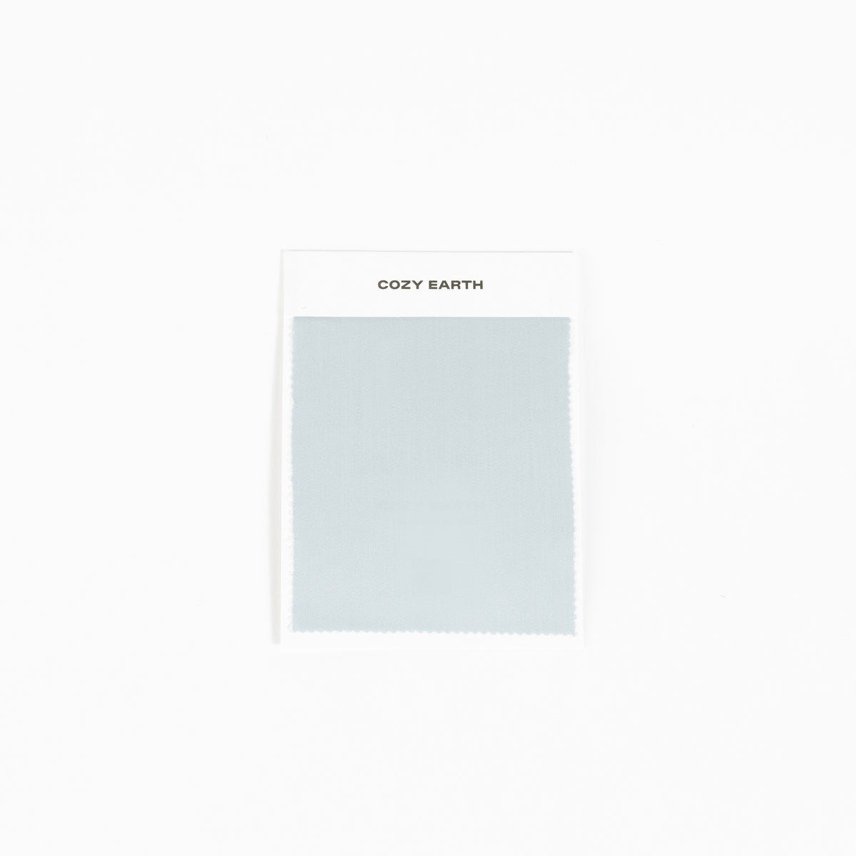 A sample of the bamboo sheet fabric in light gray is displayed against a white background, mounted on a card labeled with "Cozy Earth" at the top. 