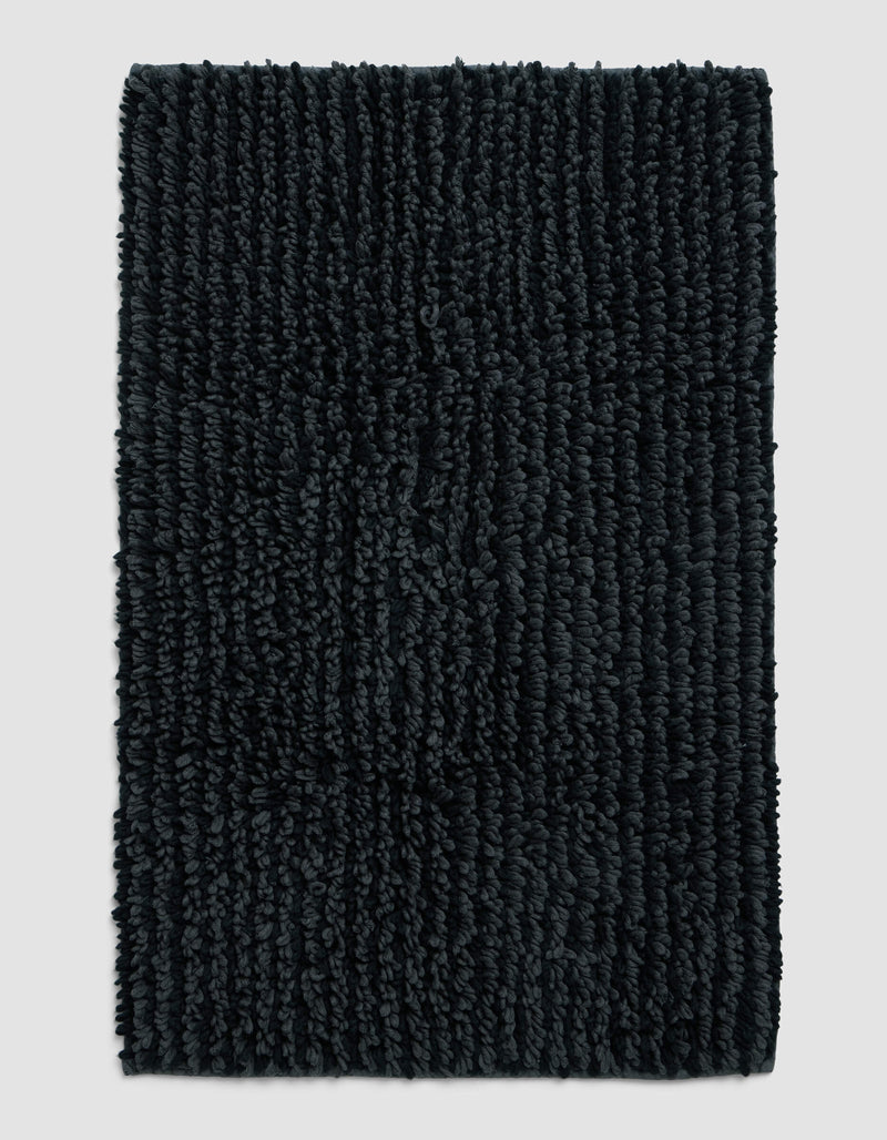 The Cozy Earth Plush Loop Bath Mat, rectangular and dark gray with thick textured fibers, is displayed on a plain light gray background.