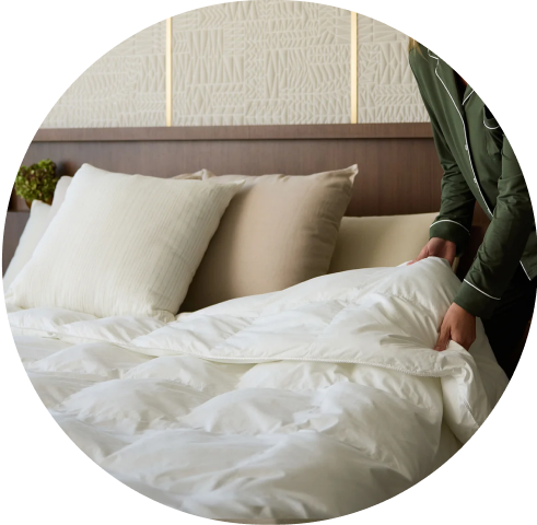 Woman making bed using Cozy Earth comforter
