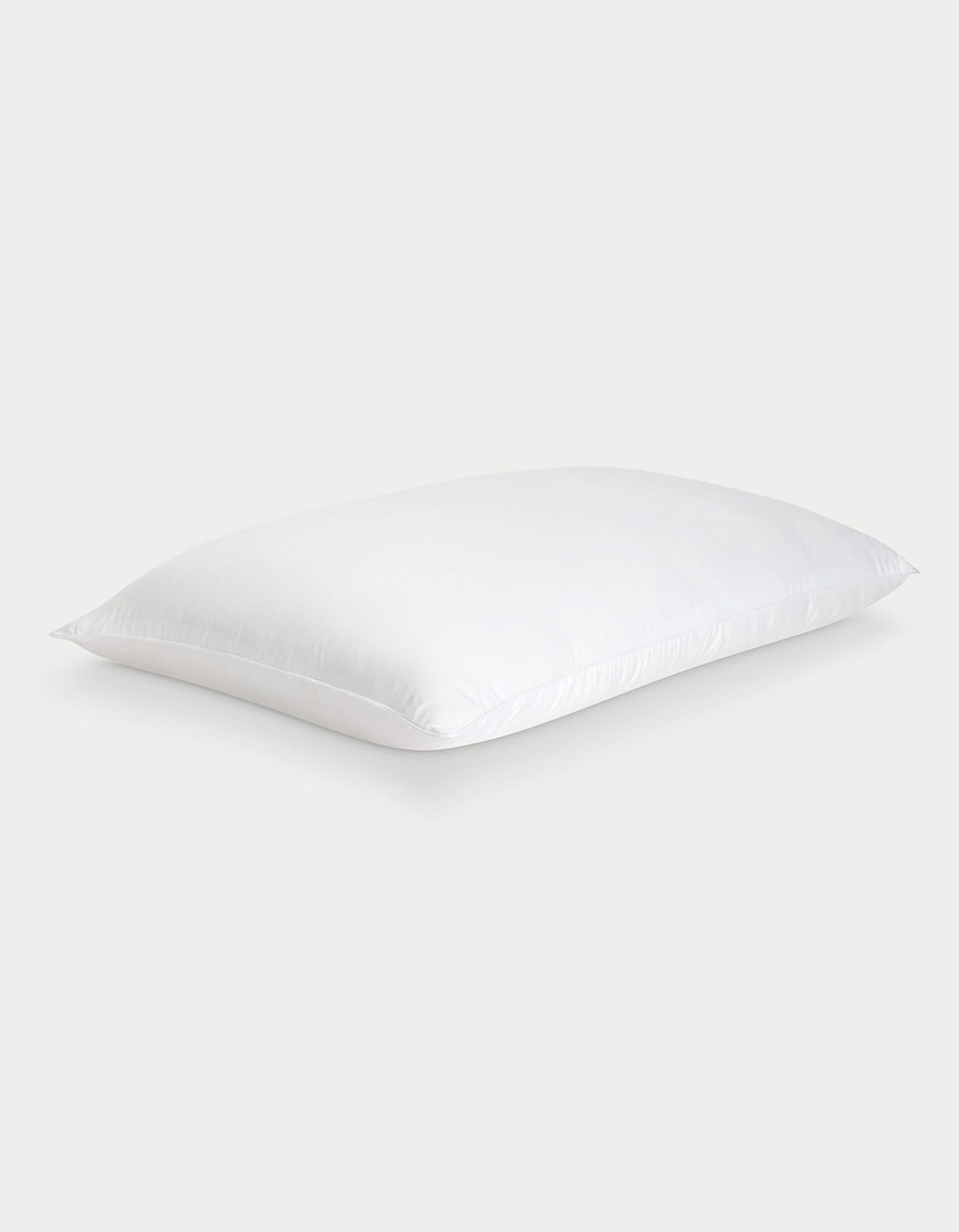 The Cozy Earth Silk Pillow, soft and rectangular with neatly finished edges, is shown against a light gray background. Its smooth white fabric highlights the luxurious feel of this premium pillow.