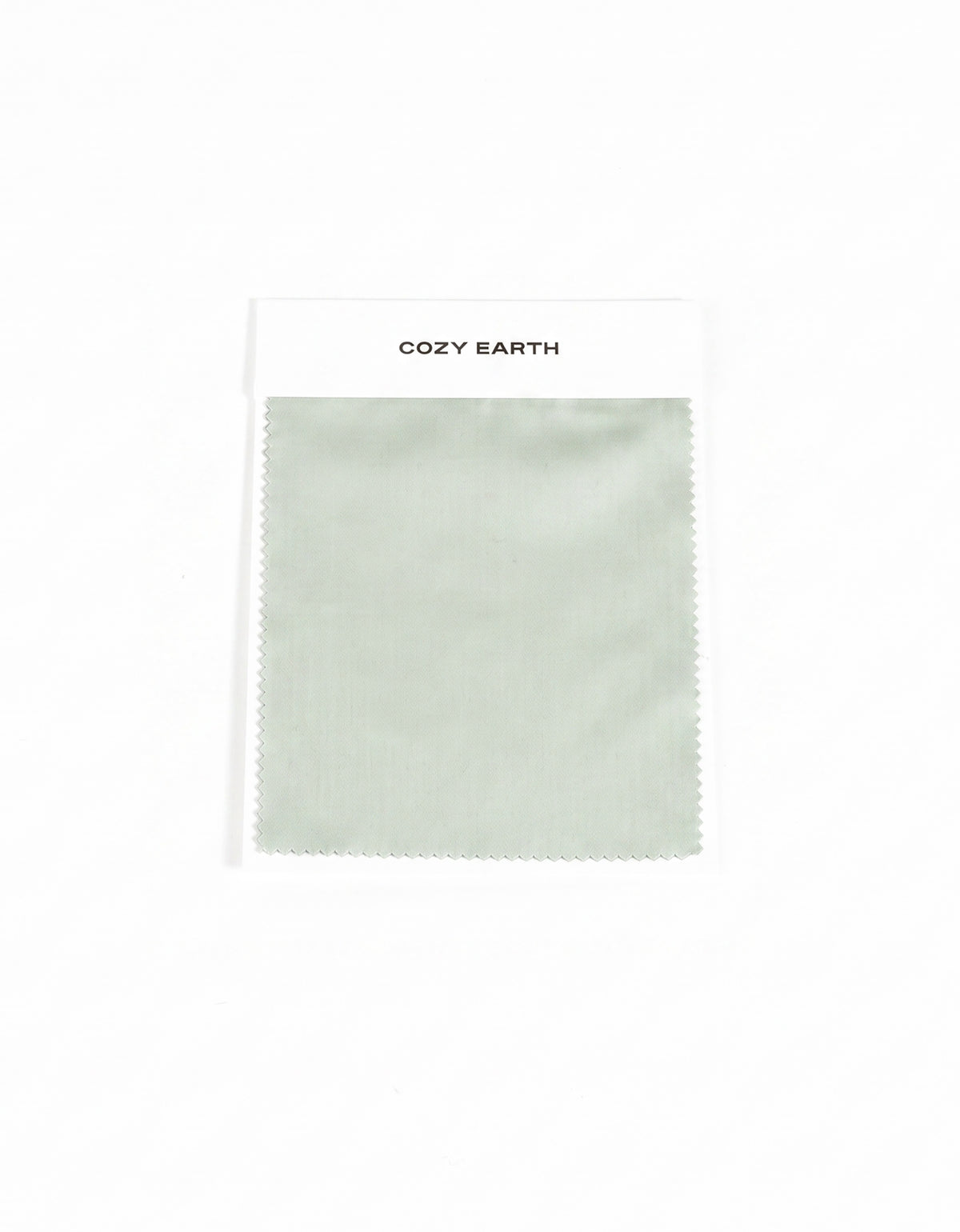 A rectangular Soft-Wash Cotton Sheet Swatch in light sage green is shown on a white card labeled "Cozy Earth" at the top, set against a plain white background.