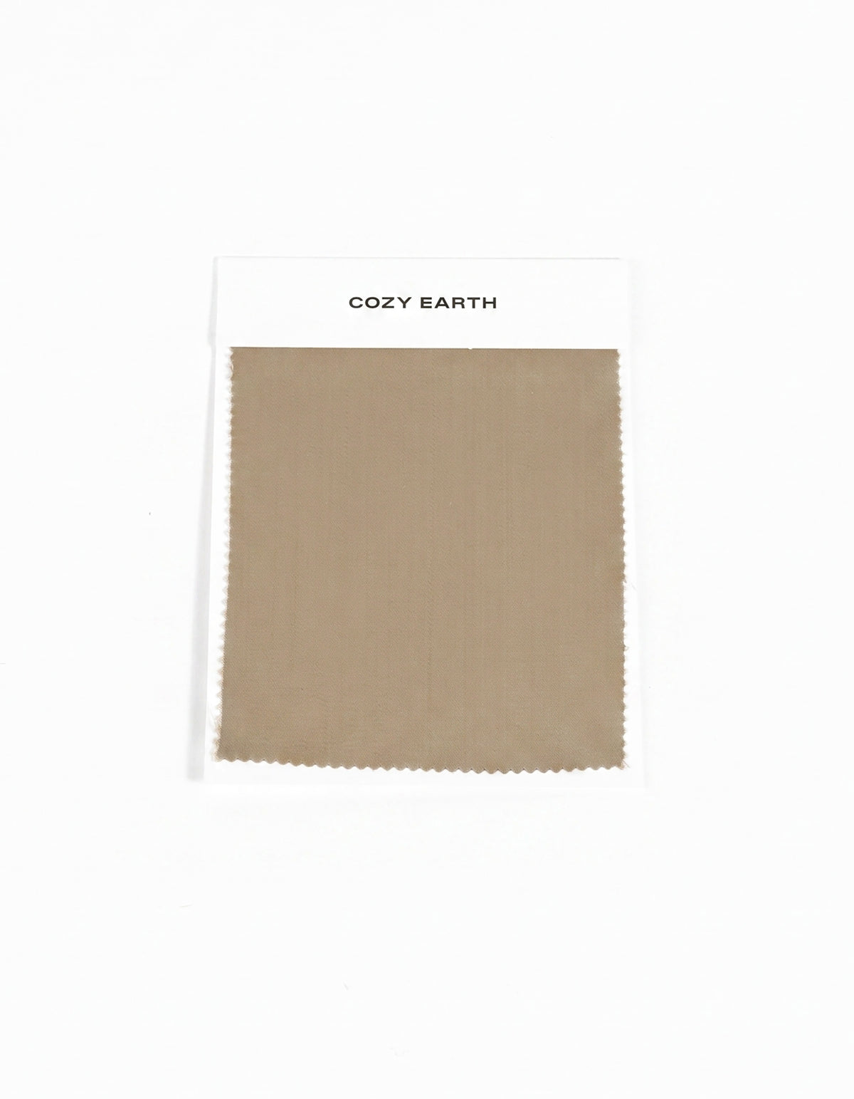 A rectangular beige swatch of Soft-Wash Cotton Sheet from Cozy Earth is attached to a white card labeled "Cozy Earth" on a plain white background.
