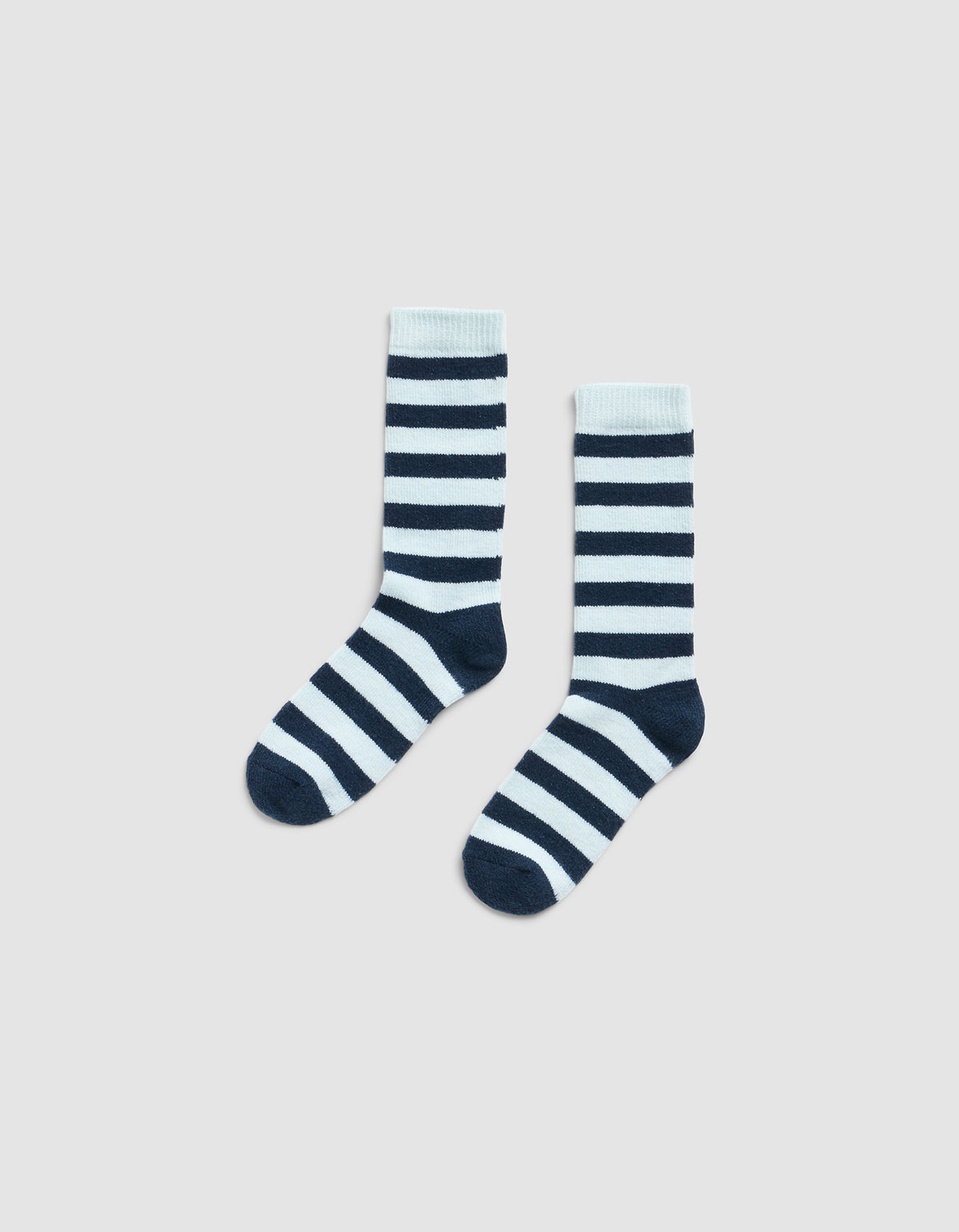 The Striped Plush Lounge Sock by Cozy Earth, featuring horizontal black and white stripes, is shown side by side on a plain light gray background.
