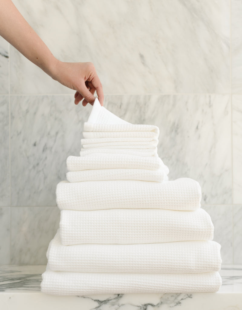 Complete Waffle Bath Bundle in the color White. Photo of White Complete Waffle Bath Bundle taken resting on a marble counter top.