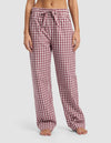 A woman stands barefoot wearing Cozy Earth Women's Sutton Pajama Pant, featuring a loose fit and red and white checkered pattern with a drawstring waistband, shown from shoulders down against a plain white background.|Color:Mulberry Gingham