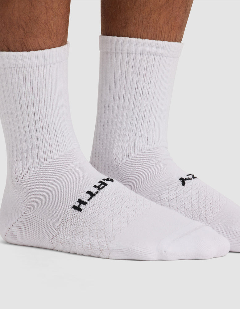 White Cozy Earth Essential Calf Socks with black branding on a light gray background