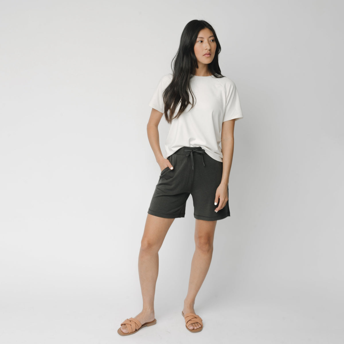Woman wearing a white t-shirt and grey Cozy Earth Brushed Bamboo Mid-Length Shorts shorts on a plain background 